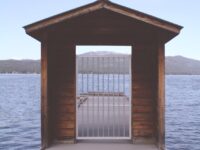 brown wooden dock with white metal fence