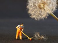 shallow focus photo of man holding floor brush ceramic figurine